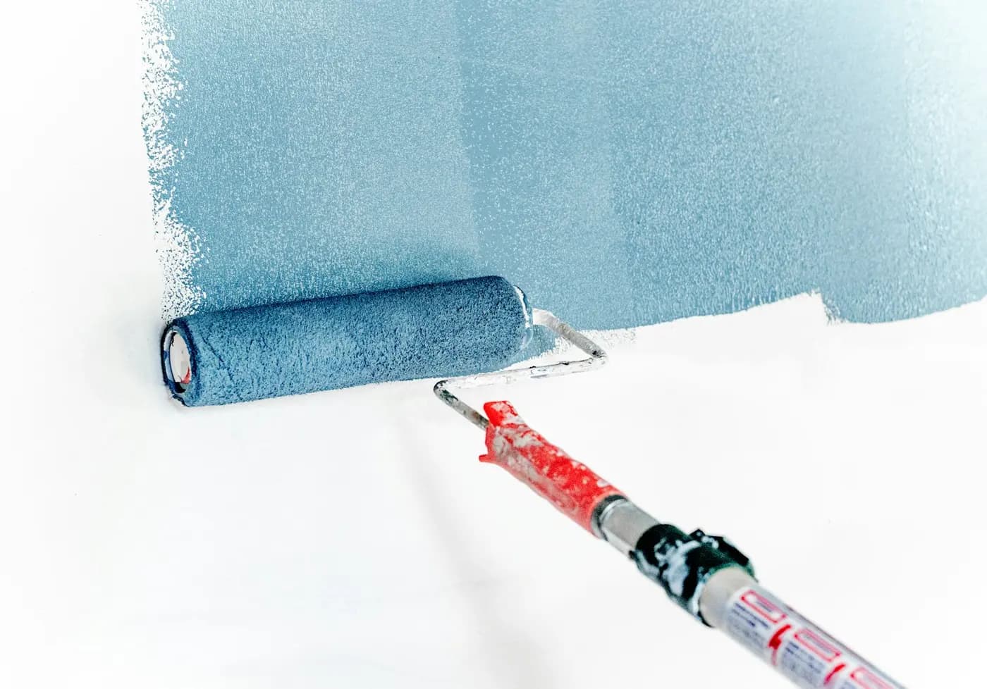Paint roller applying blue paint